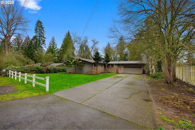 view of front of house featuring a front lawn, fence, concrete driveway, an attached garage, and brick siding