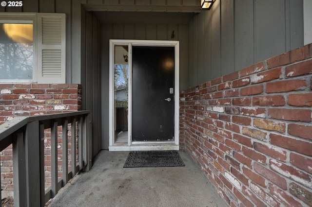 view of exterior entry featuring brick siding