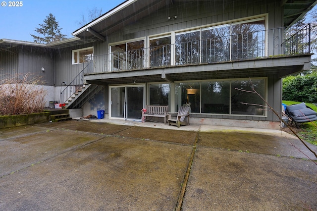 back of property with a patio area and stairway