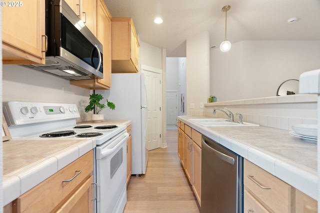 kitchen with appliances with stainless steel finishes, decorative light fixtures, sink, tile counters, and light brown cabinets