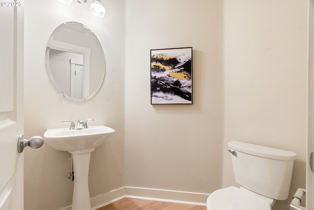 bathroom with toilet and hardwood / wood-style floors