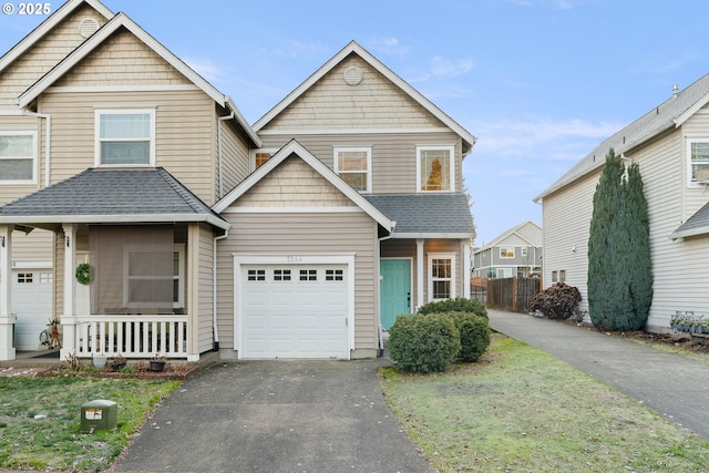 view of front of house with a garage, a front yard, and covered porch