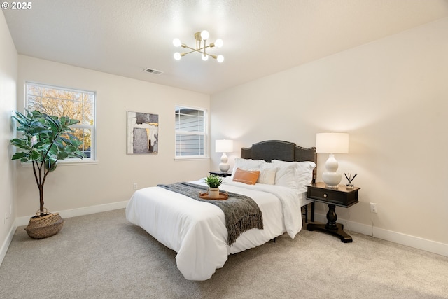 bedroom featuring light colored carpet and an inviting chandelier