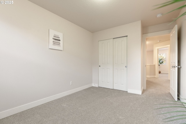 unfurnished bedroom featuring a closet and light carpet