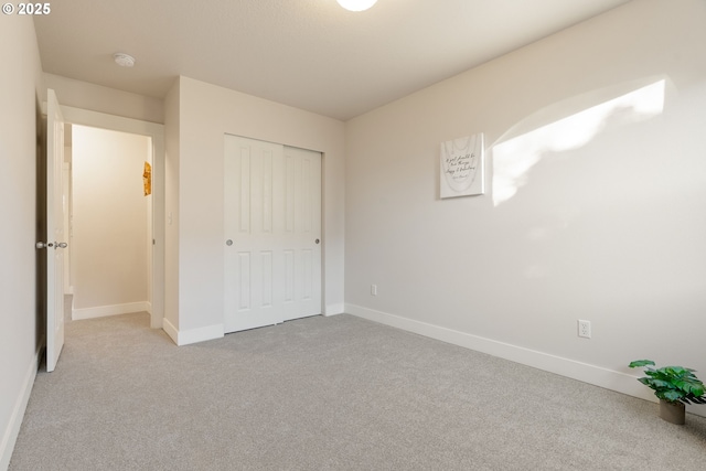 unfurnished bedroom featuring light colored carpet and a closet