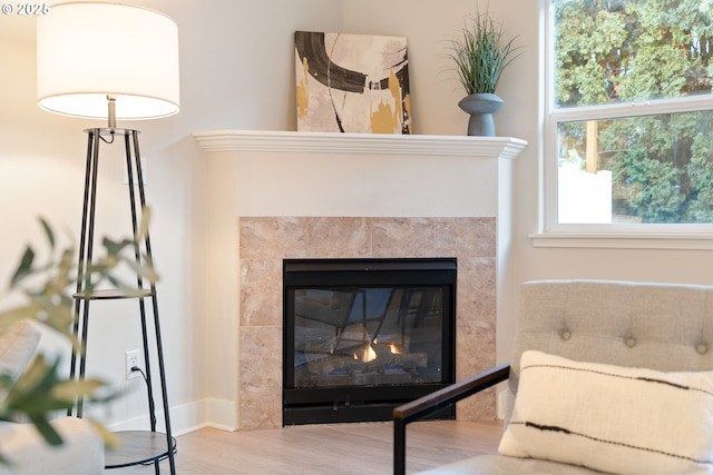 interior details featuring hardwood / wood-style flooring and a tile fireplace