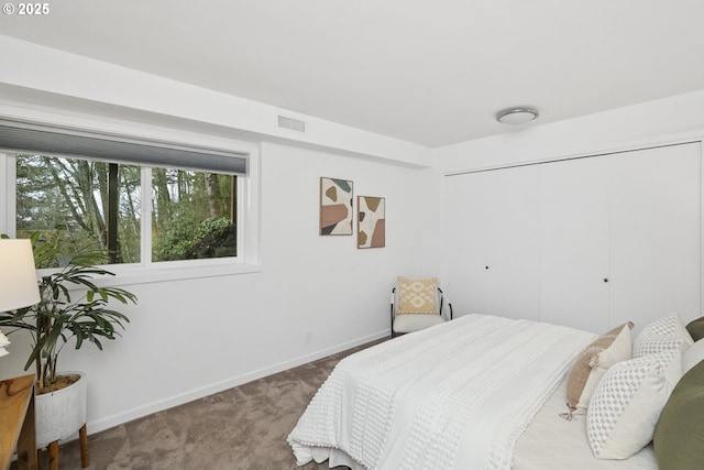 carpeted bedroom with a closet, visible vents, and baseboards