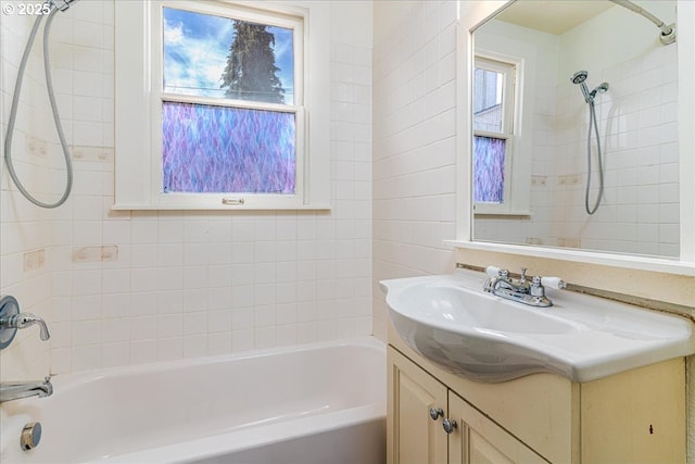 bathroom featuring tiled shower / bath combo and vanity