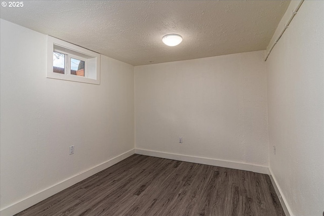 basement featuring dark wood-type flooring and a textured ceiling