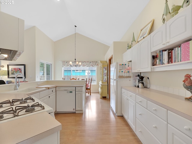 1689 Huckleberry Dr, Seaside, OR 97138 - kitchen with white appliances, a chandelier, light countertops, light wood-style floors, and white cabinets