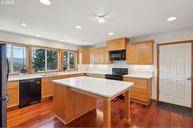 kitchen featuring dark hardwood / wood-style floors, a center island, sink, and black appliances