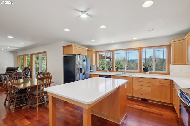 kitchen with dark hardwood / wood-style floors, light brown cabinetry, sink, stainless steel fridge, and electric stove