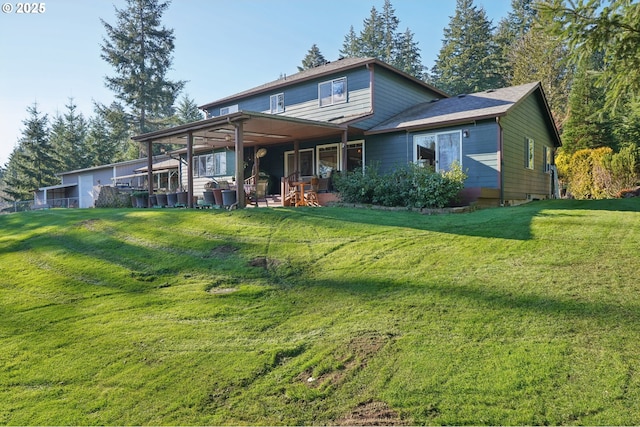 rear view of house featuring a lawn