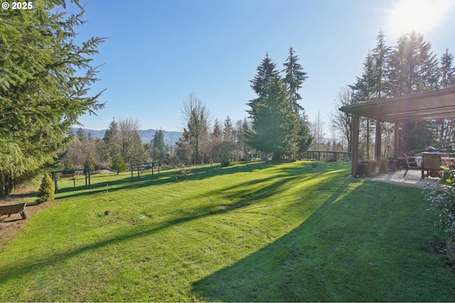 view of yard with a mountain view, a pergola, and a patio area