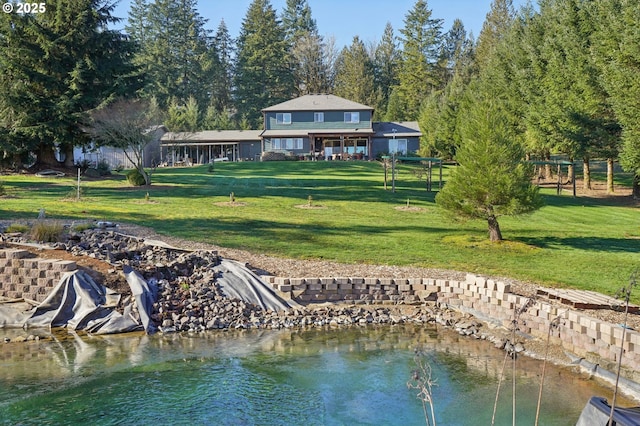 back of property featuring a yard and a water view