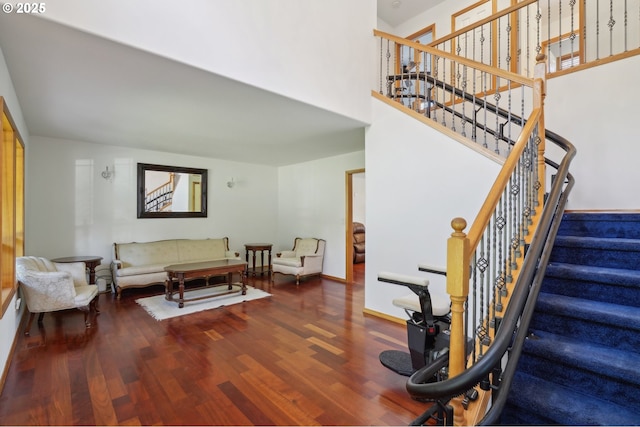 staircase with hardwood / wood-style floors and a towering ceiling