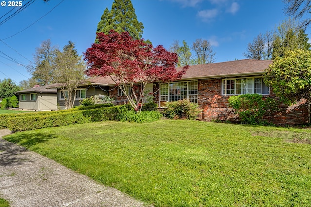 ranch-style house with a front lawn and brick siding