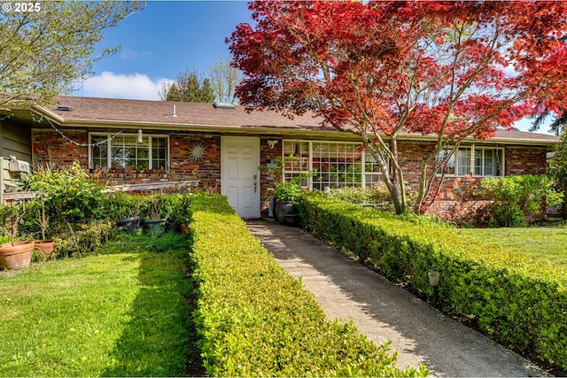 single story home featuring a front lawn and brick siding