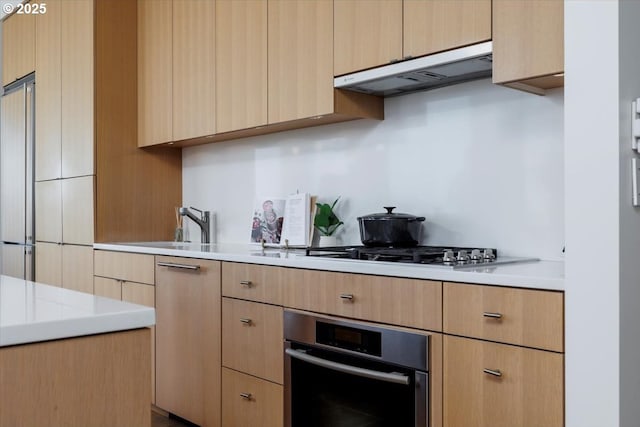 kitchen with gas cooktop, stainless steel oven, and light brown cabinets