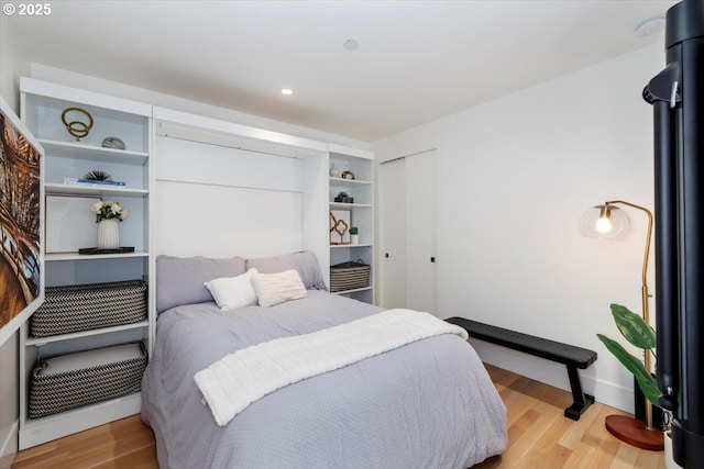 bedroom with light hardwood / wood-style floors and a closet