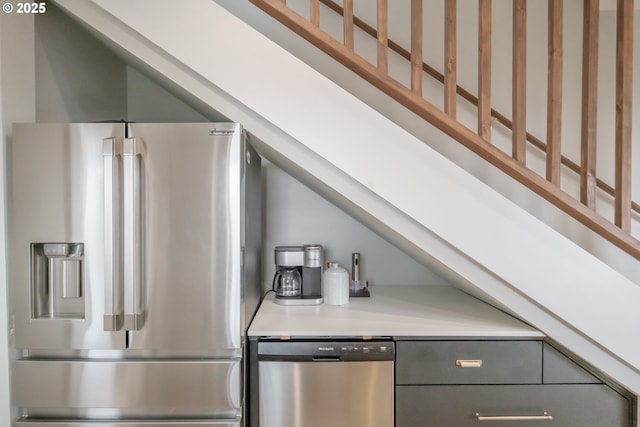 kitchen featuring stainless steel appliances, light countertops, and gray cabinetry