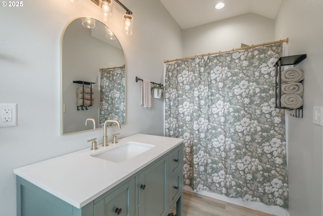 full bath with lofted ceiling, wood finished floors, and vanity