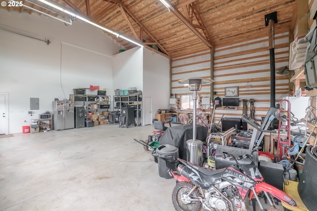 garage with electric panel and stainless steel refrigerator with ice dispenser