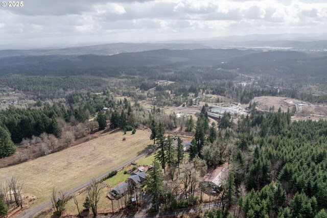 aerial view of property and surrounding area with a heavily wooded area and a mountainous background