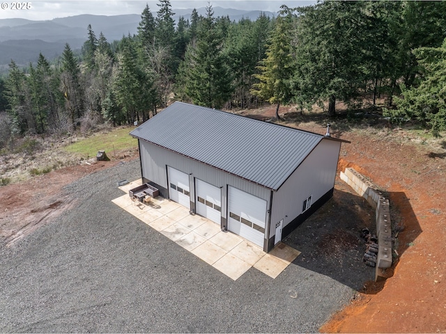 drone / aerial view featuring a mountain view and a wooded view