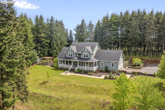 view of front of home with a porch, a front lawn, a view of trees, and a gazebo