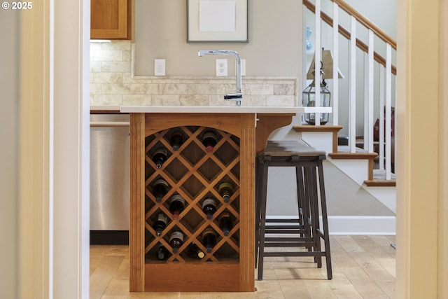 bar area with decorative backsplash, stairs, and baseboards