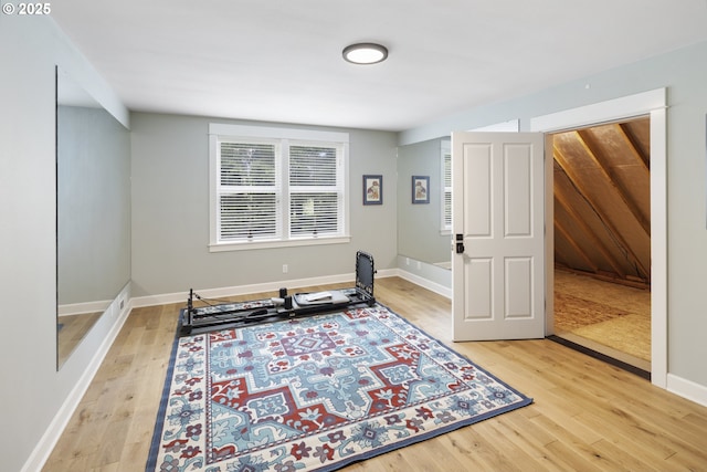 workout room with light wood-style flooring and baseboards