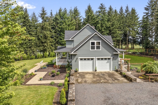 traditional home with covered porch, driveway, a garage, roof with shingles, and view of wooded area