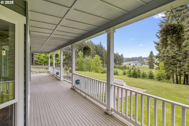 wooden deck featuring a yard and covered porch