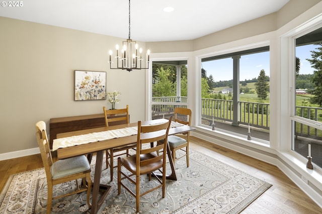 dining area featuring hardwood / wood-style flooring, a chandelier, and baseboards