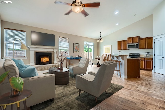 1080 Sage St, Silverton, OR 97381 - living area featuring light wood-type flooring, a ceiling fan, a tile fireplace, recessed lighting, and high vaulted ceiling