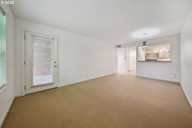 1500 SW Park Ave, Portland, OR 97201 - unfurnished living room with visible vents, baseboards, and light carpet