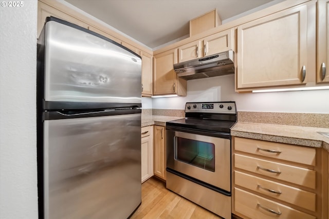 1500 SW Park Ave, Portland, OR 97201 - kitchen featuring light brown cabinetry, under cabinet range hood, light wood-style floors, tile counters, and stainless steel appliances