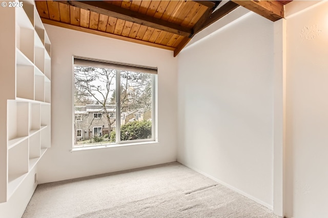 empty room featuring wood ceiling, carpet flooring, and lofted ceiling with beams