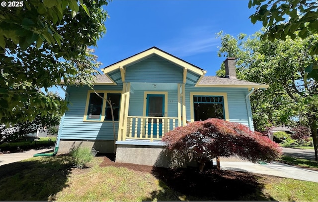 735 SE Spokane St, Portland, OR 97202 - bungalow-style home with a chimney, a shingled roof, and covered porch