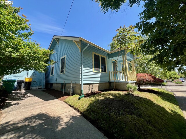 735 SE Spokane St, Portland, OR 97202 - view of side of property with covered porch and a lawn