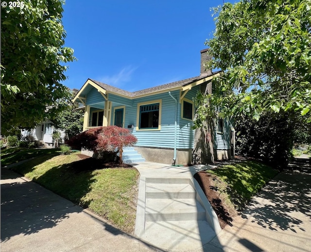 735 SE Spokane St, Portland, OR 97202 - view of front of property with a chimney and a front yard