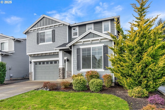 craftsman inspired home featuring board and batten siding, a front yard, a garage, stone siding, and driveway