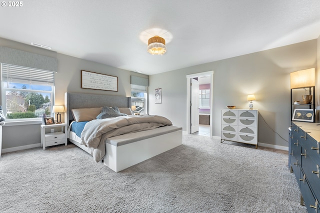 bedroom featuring light carpet and ensuite bath