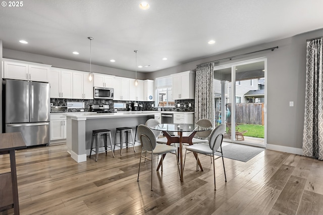 dining area featuring recessed lighting, baseboards, and wood finished floors