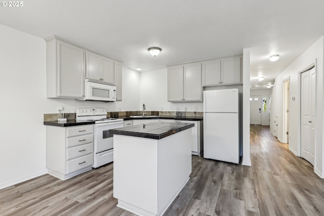 kitchen featuring light hardwood / wood-style floors, sink, white appliances, and white cabinets