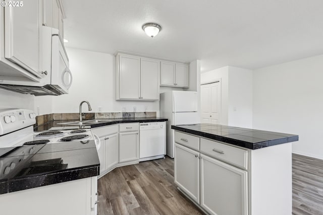 kitchen with white cabinetry, white appliances, hardwood / wood-style floors, and a kitchen island