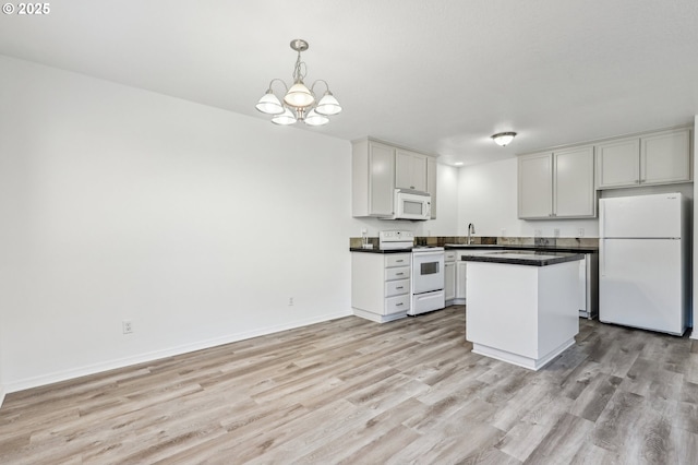 kitchen featuring white appliances, decorative light fixtures, an inviting chandelier, sink, and light wood-type flooring