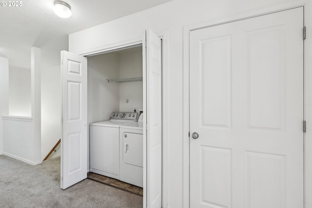 clothes washing area with washing machine and clothes dryer and light carpet