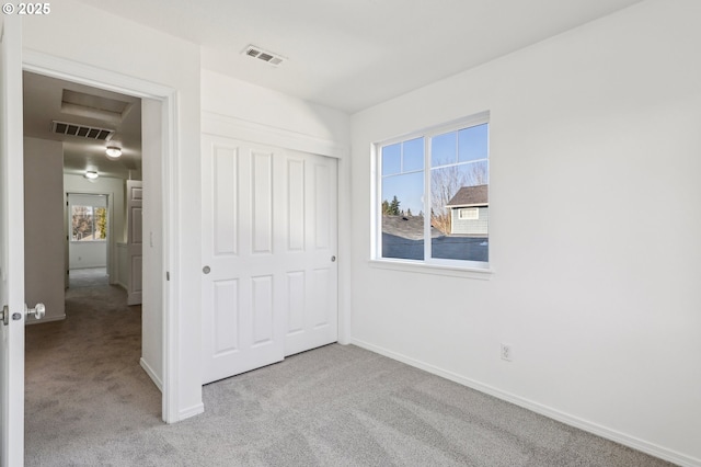 unfurnished bedroom featuring a closet and light carpet